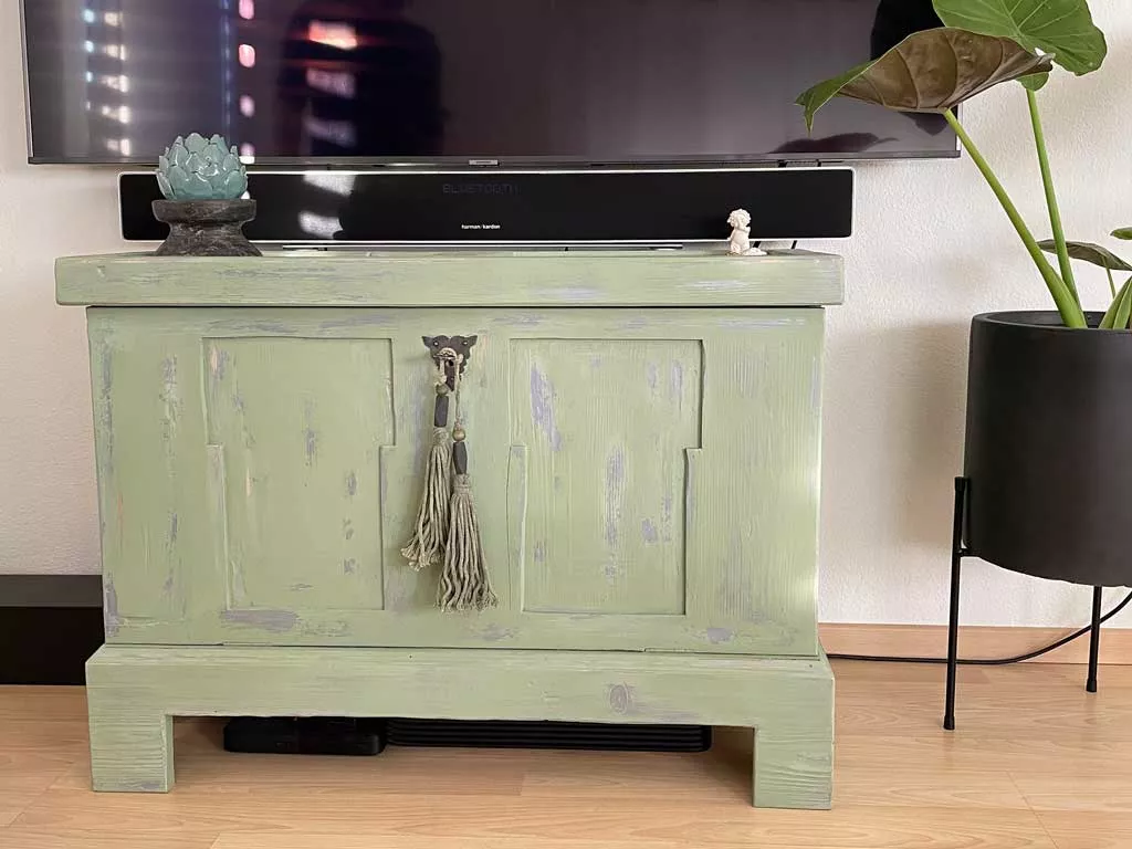 Grün lasierte, im Vintage-Stil aufgearbeitete Holzkommode als TV-Möbel