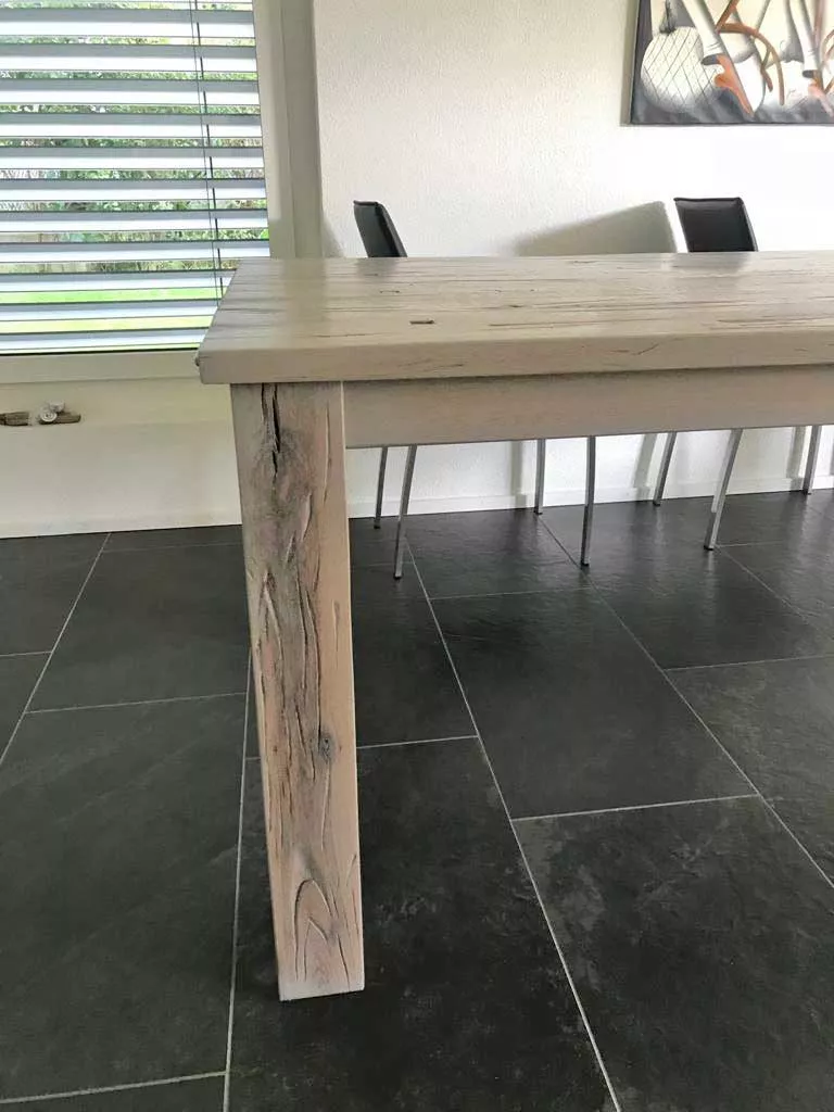 Aufgearbeiteter Holztisch mit heller, weiss naturgeölter Oberfläche und markantem Massivholz-Bein
