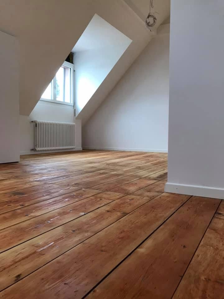 Dielenboden unter Dachschräge mit Heizkörper und Dachfenster